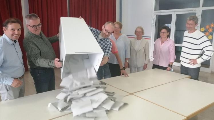 Wahlvorstand Jochen Busse (links) beobachtet in der Oberschule Bad Essen mit seinem Team, wie Ralf Krone und Daniel Adler die Stimmzettel ausschütten.