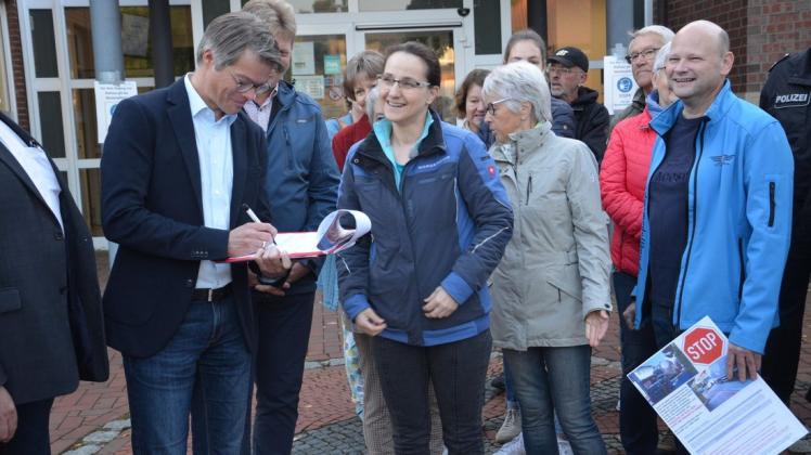 Die Übergabe der Unterschriftslisten lassen sich Susanne Laumann-Borcherding (Mitte) und ihre Mitstreiter von Jürgen Rolfsen schriftlich bestätigen.