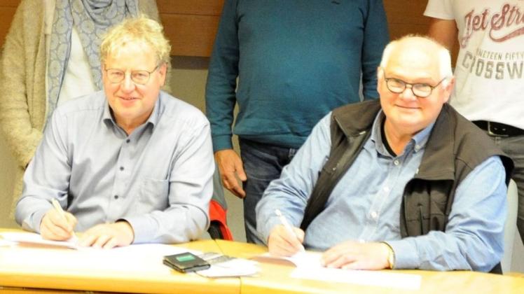 Ankums Bürgermeister Detert Brummer-Bange (links) und sein Kettenkamper Kollege Reinhard Wilke unterzeichnen die Verträge für die gemeinsame Dorfentwicklung.
