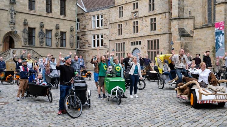 30 Lastenradfahrer versammelt sich in Osnabrück auf dem Platz vor dem Rathaus.