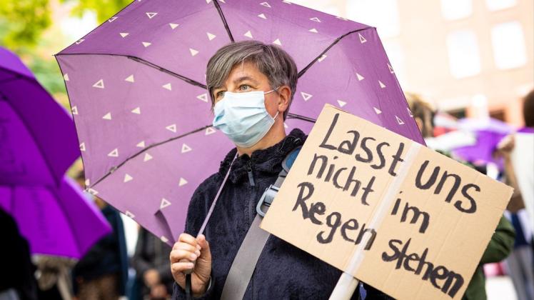 "Lasst und nicht im Regen stehen" steht auf dem Plakat einer Frau bei einer Demonstration für Frauenhäuser vor dem niedersächsischen Landtag. Der Protest richtet sich gegen geplante Änderungen in der Förderrichtlinie für Frauenhäuser.