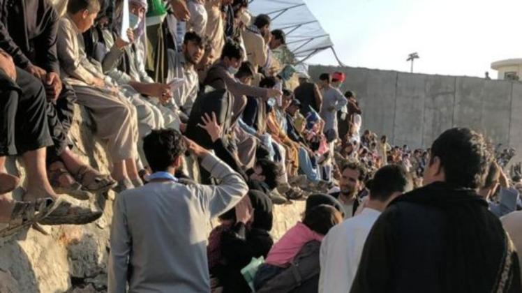 Hamid (links in heller Kleidung mit dem Rücken zur Kamera) versucht, wie Tausende andere auch, auf das Gelände des Flughafens von Kabul zu gelangen.