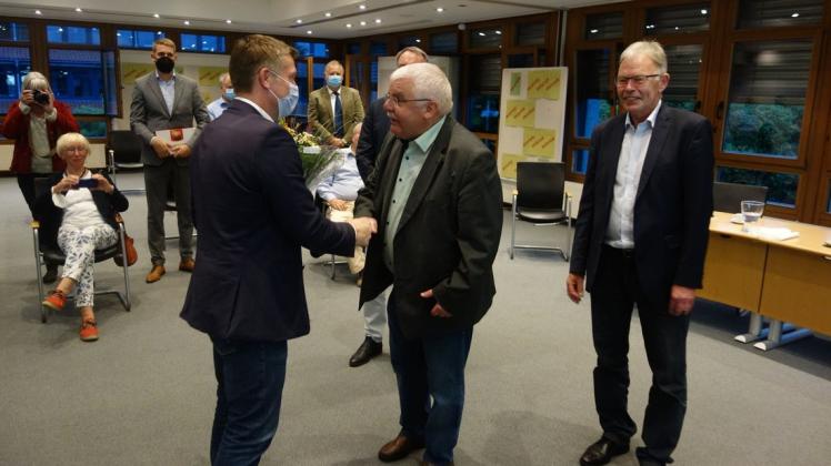 Glückwünsche an den neuen Landrat: Der Kreistagsvorsitzende Hartmut Post gratuliert im Sitzungssaal des Kreishauses Christian Pundt (links), der am 1. November den scheidenden Carsten Harings (rechts) im Amt ablösen wird.