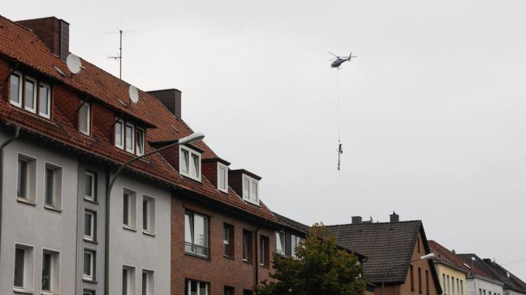 Mithilfe eines Helikopters werden in Osnabrück  spezielle Masten aufgestellt.