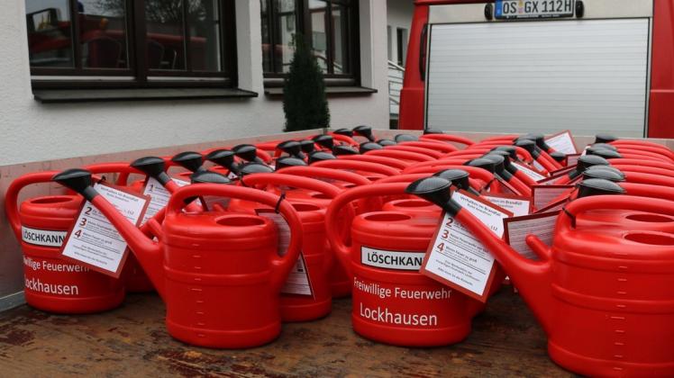 Werbeaktion für die Ortswehr Lockhausen mit beschrifteten und gefüllten roten Löschkannen.