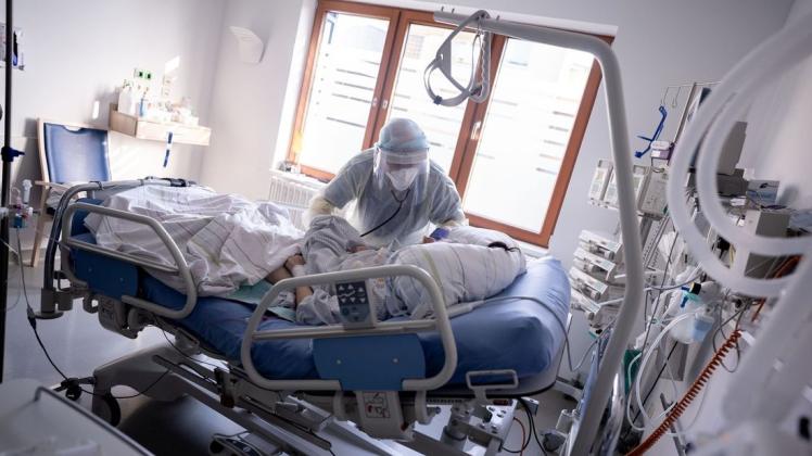 Ein Intensivpfleger arbeitet auf der Intensivstation des Krankenhauses Bethel in Berlin an einer Corona-Patientin.