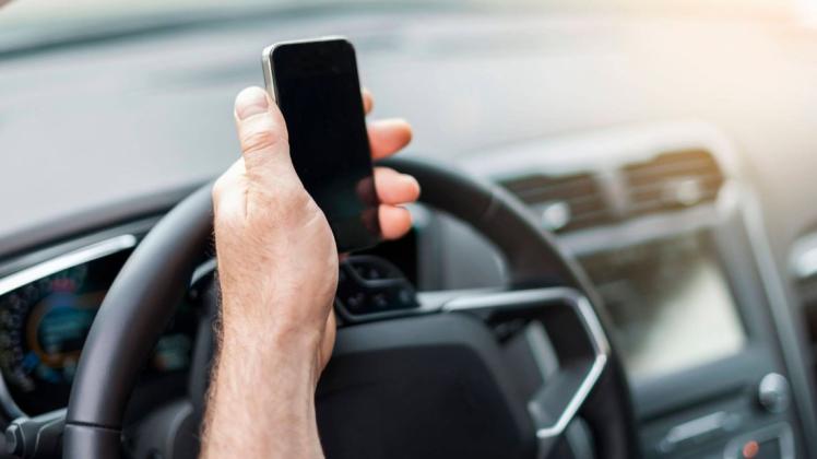 Trotz drohenden Bußgelds, schauen Autofahrer häufig während der Fahrt auf ihr Smartphone. Die Polizei Delmenhorst warnt vor den Gefahren.