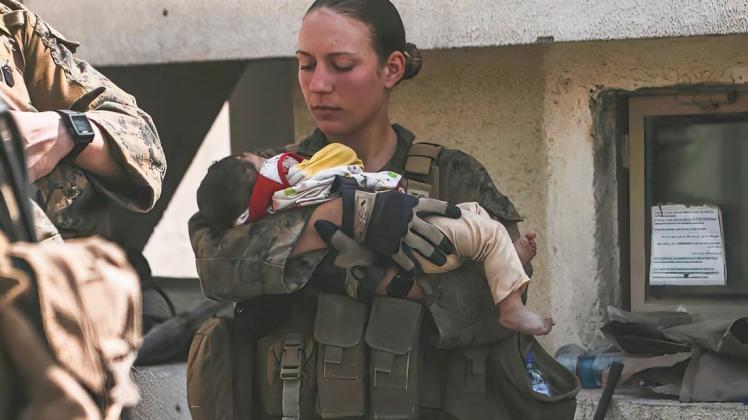 "Ich liebe meine Job" schrieb Sgt. Nicole Gee zu diesem Foto: Sie beruhigte Kleinkinder während einer Evakuierung am Hamid Karzai International Airport in Kabul, Afghanistan. Wie die Behörden am 28. August mitteilten, war Gee aus Sacramento, Kalifornien, eine der Marines, die bei dem Bombenanschlag am Donnerstag auf dem Flughafen getötet wurden.