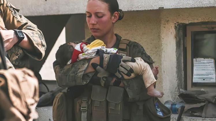In diesem Bild vom 20. August 2021, das vom US Marine Corps zur Verfügung gestellt wurde, beruhigte Nicole Gee ein Kleinkind während einer Evakuierung am Hamid Karzai International Airport in Kabul, Afghanistan. Tage später starb die 23-Jährige bei einem Terroranschlag auf den Flughafen.