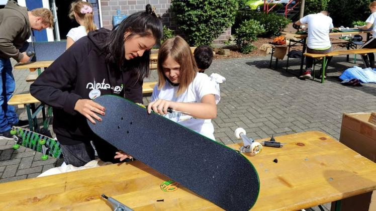 Beim Skate-Aid-Workshop in Belm half Trami Pham (links) Lana (10) beim Zusammenschrauben ihres Skateboards. Denn bevor die Ferienspaß-Kinder losskaten konnten, mussten sie zunächst ihr Board zusammenschrauben.