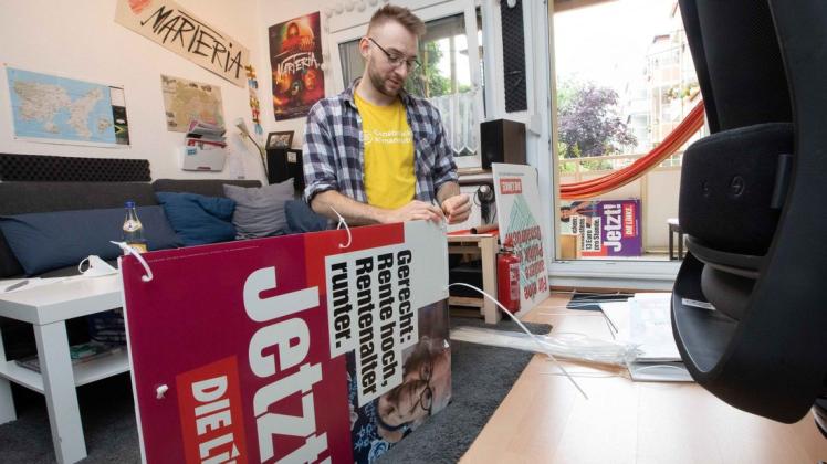 Platz ist in der kleinsten Hütte: Jan-Philip Cröplin, der OB-Kandidat der Linken, präpariert Wahlplakate in seiner Zweizimmerwohnung, die er sich mit seiner Freundin teilt.