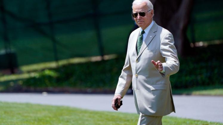 Joe Biden, Präsident der USA, winkt im beigen Anzug.