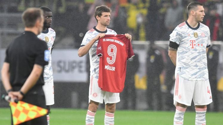 Vor Beginn der Partie wird mit einer Schweigeminute der verstorbenen Fußballlegende Gerd Müller gedacht. Münchens Mittelfeldspieler Thomas Müller hält dabei ein Trikot mit dem Namen des berühmten Stürmers.