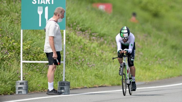 Szene mit Folgen: Radsport-Direktor Patrick Moster (links) steht beim olympischen Zeitfahren neben  der Strecke, als der AlgerierAzzedine Lagab vorbeifährt.