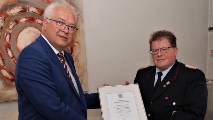 Bürgermeister Ansgar Brockmann ernennt Friedrich Dortelmann (r.) zum Ehrengemeindebrandmeister von Neuenkirchen-Vörden.
