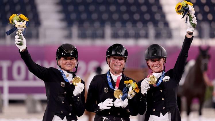 Dorothee Schneider, Isabell Werth und Jessica von Bredow-Werndl (von links) freuen sich über ihre Goldmedaille.