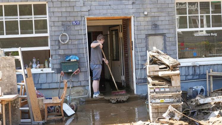 Hausbesitzer kehren den Schlamm aus ihren Häusern. Nach der Hochwasserkatastrophe hat Bundesfinanzminister Olaf Scholz Soforthilfen in dreistelliger Millionenhöhe in Aussicht gestellt.