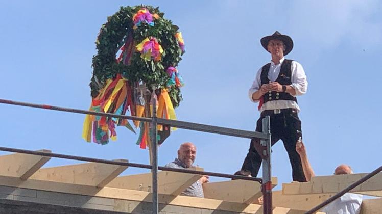 Zimmermann Kurt Grefenkamp hat den Dachstuhl gerichtet und den Kranz gesetzt. Auch der stellvertretende Bürgermeister, Rainer Duffe, freut sich.