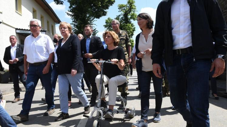 Die auf einem Elektromobil fahrende Malu Dreyer, Ministerpräsidentin von Rheinland-Pfalz, besucht im Beisein von Bundeskanzlerin Angela Merkel die vom Hochwasser verwüsteten Gebiete.