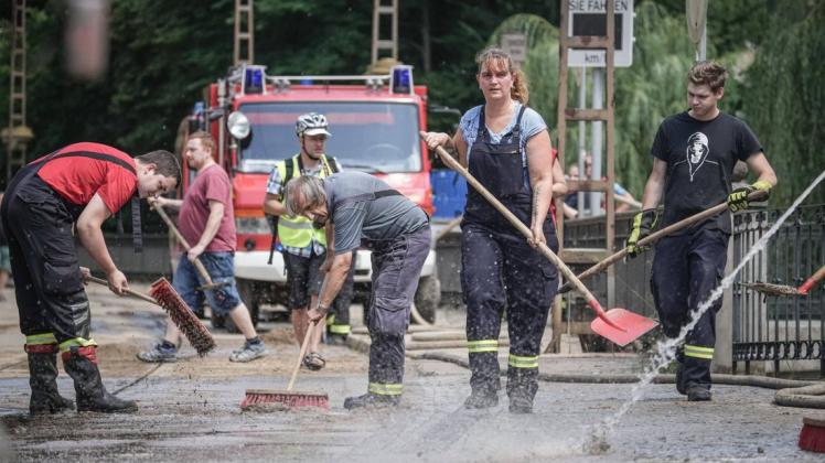 Feuerwehr und freiwillige Helfer kommen in den Katastrophengebieten zusammen – eine mögliche Corona-Ansteckungsgefahr.