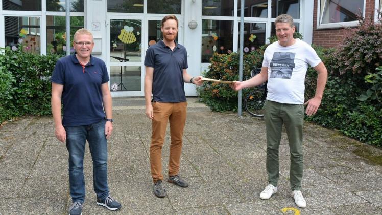 Volker Stuckenberg, Christian Grade und Jürgen Westerhaus (von links) bei der symbolischen Spendenübergabe des Windparks an die Honigmoor-Schule.