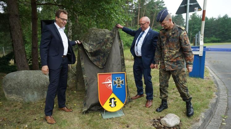 Das neue Wappen des Lagers haben Werltes Samtgemeindebürgermeister Ludger Kewe (von links), Lorups Bürgermeister Wilhelm Helmer und Generalleutnant Martin Schelleis enthüllt.