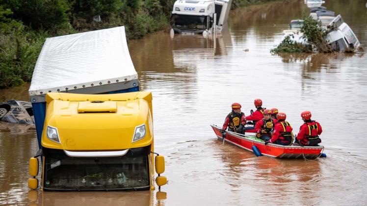 In Erftstadt suchen Helfer der Wasserwacht auf der überfluteten Bundesstraße 265 nach Überlebenden.