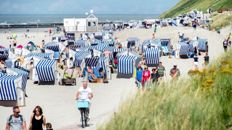 Urlaubsgäste sitzen bei sonnigem Wetter in ihren Strandkörben am Nordstrand der Insel Norderney. Foto: Hauke-Christian Dittrich/dpa
