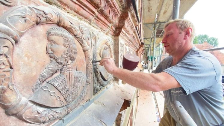 Auch der Steinmetz Steve Schreiter vom Unternehmen Hollerung ist an der Terrakotten-Restaurierung beteiligt. Hier öffnet er mit einem Meißel Fugen.