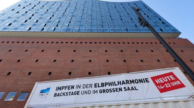 Ein Plakat vor der Elbphilharmonie in Hamburg weist auf die Impfaktion des Veranstaltungshauses hin.