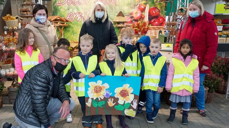 Kinder von der Kita Schreberstraße bedanken sich mit einem selbst gemalten Bild bei Geschäftsführer Ralph Arkenau für das Blumenzwiebel-Geschenk.