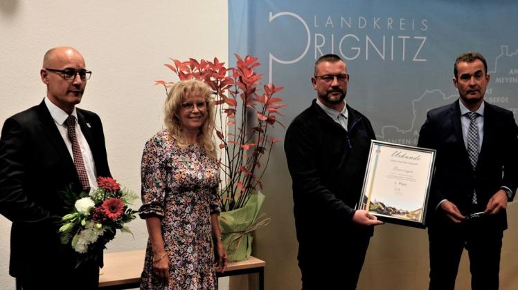 Pritzwalks Bürgermeister Roland Thiel, Jury-Vorsitzende Kerstin Meyer, Ortsvorsteher Markus Milord und Landrat Torsten Uhe bei der Auszeichnung.