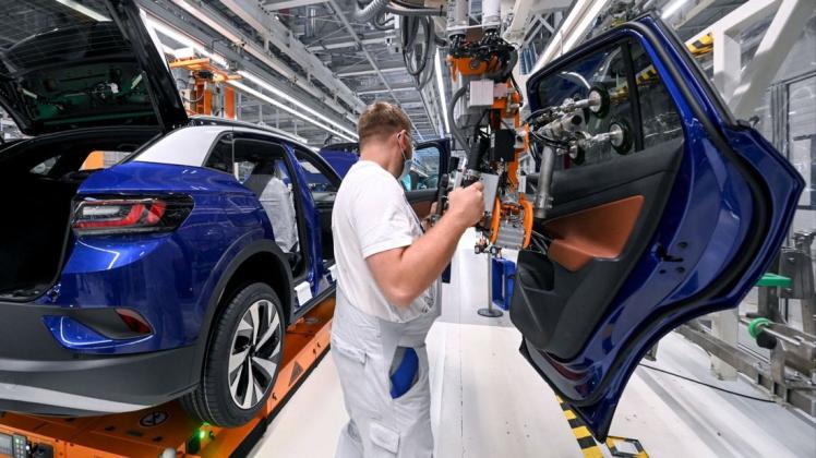 Ein Mitarbeiter im Volkswagenwerk in Zwickau komplettiert einen VW ID.4. Was ist dran an den mutmaßlichen Plänen von VW-Vorstandsvorsitzendem Herbert Diess, 30.000 Jobs bei Volkswagen zu streichen?