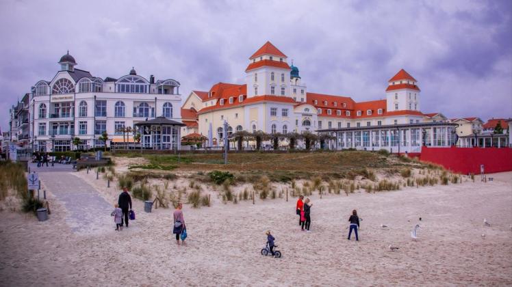 Ein paar Urlauber sind am Strand an der Ostsee vor dem Hotel Kurhaus Binz auf der Insel Rügen unterwegs. /Archiv
