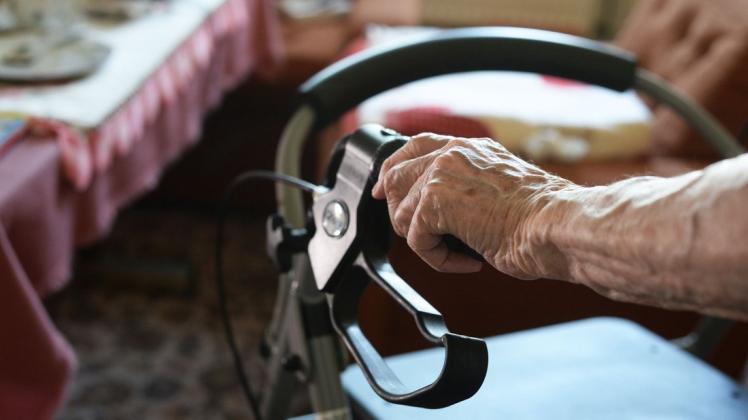Eine ältere Frau geht an einem Rollator durch ihre Wohnung. Die meisten Menschen werden zuhause gepflegt - eine hohe Belastung für Angehörige, die Unterstützung fordern. (Symbolfoto)
