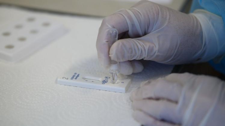 Eine Mitarbeiterin in einem Friseurstudio wertet einen Antigen-Schnelltest auf das Coronavirus aus.