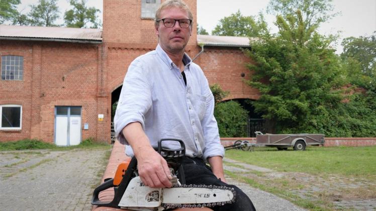 Wer von der Bundesstraße 191 in Neu Kaliß abbiegt, ist verblüfft von der alten Großmühle mitten im Ort – und der 1995 stillgelegten Papierfabrik am südlichen Rand. Die Immobilie besteht heute aus mehreren Teilen. Zu dem nicht öffentlichen Teil im Süden gehört ein Wasserkraftwerk. Günter Oldiges wichtigstes Werkzeug ist die Motorkettensäge. Er muss die Brücke auf die Insel neu beplanken.