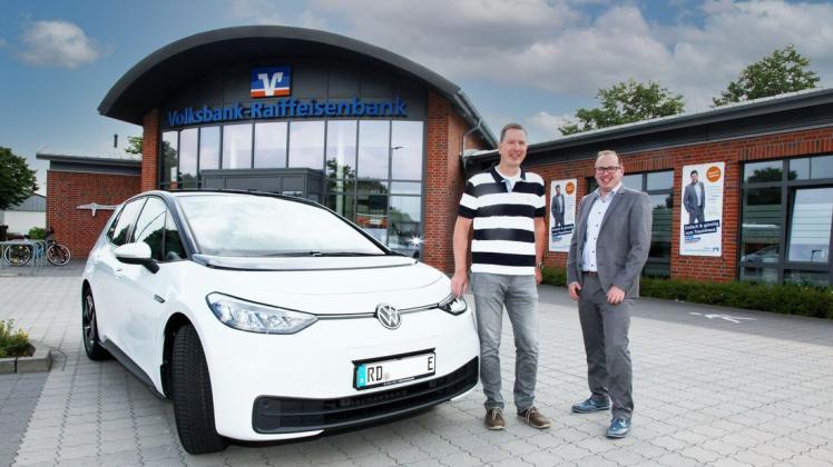 Gewinner Volker Wittfoth (links) freut sich mit VR Banker Jann Bittermann über seinen neuen VW ID.3.