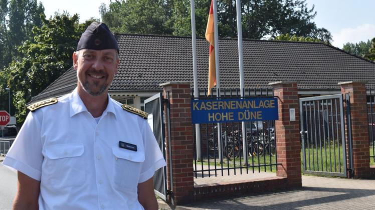 Oberstabsbootsmann Steffen Gehrke vom Marinestandort Hohe Düne ist das Bindeglied zwischen der Bundeswehr und zivilen Einrichtungen der Hansestadt Rostock und anderen Städten. Hinter ihm ist die Fahne auf Halbmast, weil sie an den Mauerbau und die vielen Mauertoten erinnert.