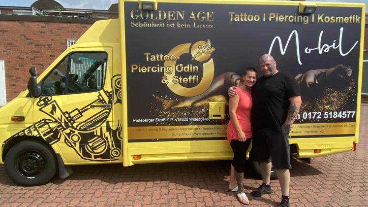 Inhaber Axel Siepenkothen und seine Lebensgefährtin Steffi Wockatz präsentieren den ehemaligen Rettungswagen, der jetzt als Tattoo-Wagen in Schwarz und Gelb glänzt.