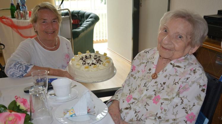 Eine Ananas-Sahne-Torte für die Jubilarin: Christel Röder präsentiert sie der 101-jährigen Lieselotte Denkers.