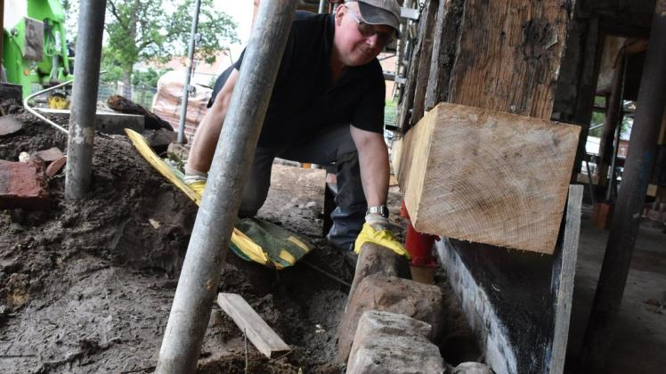 Puzzlearbeit: Unter der neu verlegten und nur auf Wagenhebern ruhenden Schwelle aus Eiche arbeitet Karsten Gäde am Fundament. Puzzlearbeit: Unter der neu verlegten und nur auf Wagenhebern ruhenden Schwelle aus Eiche arbeitet Karsten Gäde am Fundament.