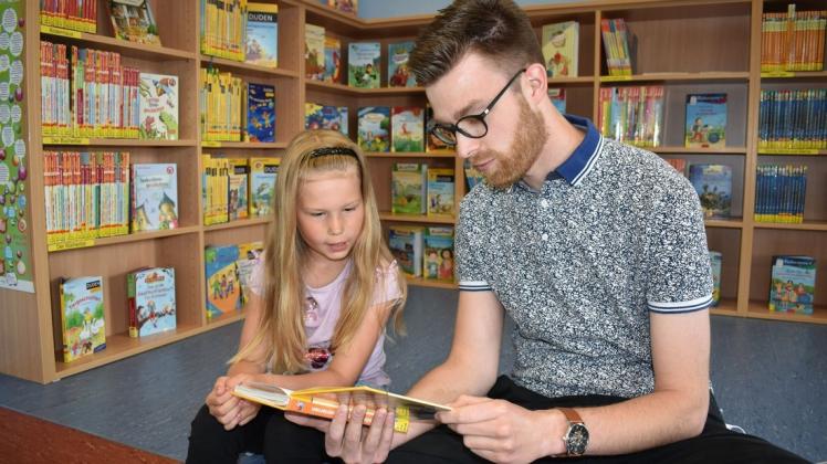 Lesen mit Spaßfaktor: In der Kinderbibliothek liest zuerst Alexander Kieslich Lena vor, dann tauschen die beiden die Rollen und die Siebenjährige liest fließend weiter.