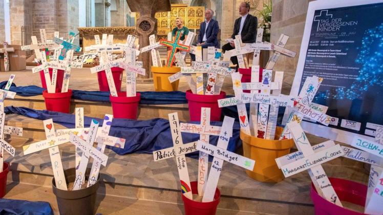 Kreuze für 796 tote Kinder haben Berufsschüler angefertigt. Sie wurden am Donnerstag präsentiert. Die Aktion wurde von John McGurk (links) initiiert. Oberbürgermeister Wolfgang Griesert und Generalvikar Ulrich Beckerwermert (rechts) nahmen ebenfalls an der Zeremonie im Dom teil.