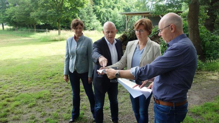 Blick auf den Plan: (von links) Dörthe Meyer (NLG), Roland Arndt (Gemeinde Hude),  Susanne Janzen (NLG), Holger Lebedinzew (Bürgermeister Hude).