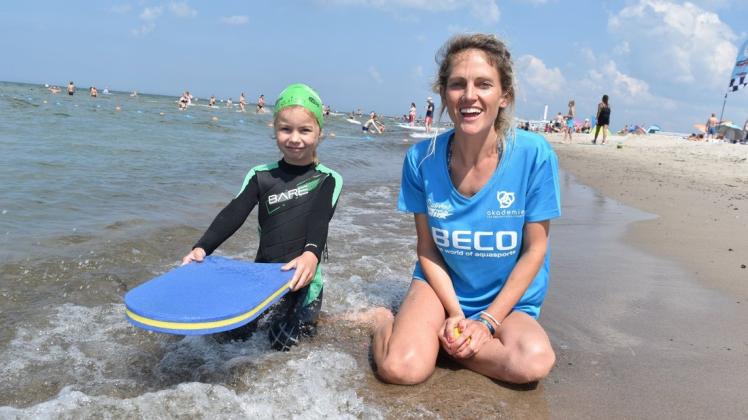 Schwimmlehrerin Anna Kuhn von Supremesurf ist stolz über die Fortschritte, die Louisa Dietrich beim Youswim-Kurs erzählt hat.