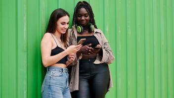 Zwei junge Frauen schauen in ihre Smartphones