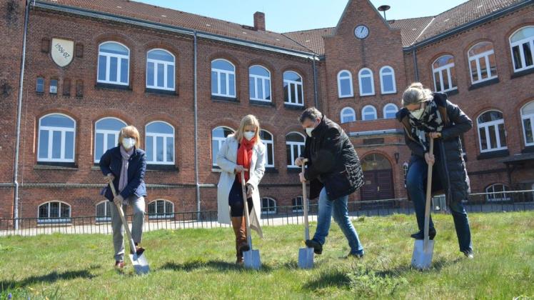 Den Spaten in den Boden zu bekommen, war nicht so einfach: Schulleiterin Jutta Bloßfeld, Bürgermeisterin Kathleen Bartels, Stadtvertretervorsteher Dirk Dobbertin und Architektin Annett Ohm (v.l.n.r.) versuchten es beim ersten Spatenstich.