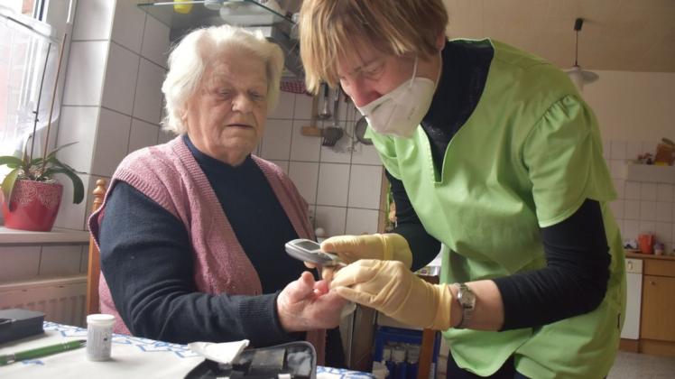 Krankenpflegerin Inka Moll überprüft die Zuckerwerte von Christa Rehbein aus Gletzow.