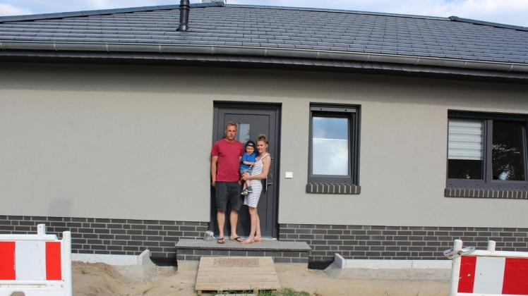 Christoph Kuhblank (l.) uns seine Frau Katja Jenns mit Sohn Emil vor dem neuen Haus. Die Außenanlagen sind noch nicht fertig.